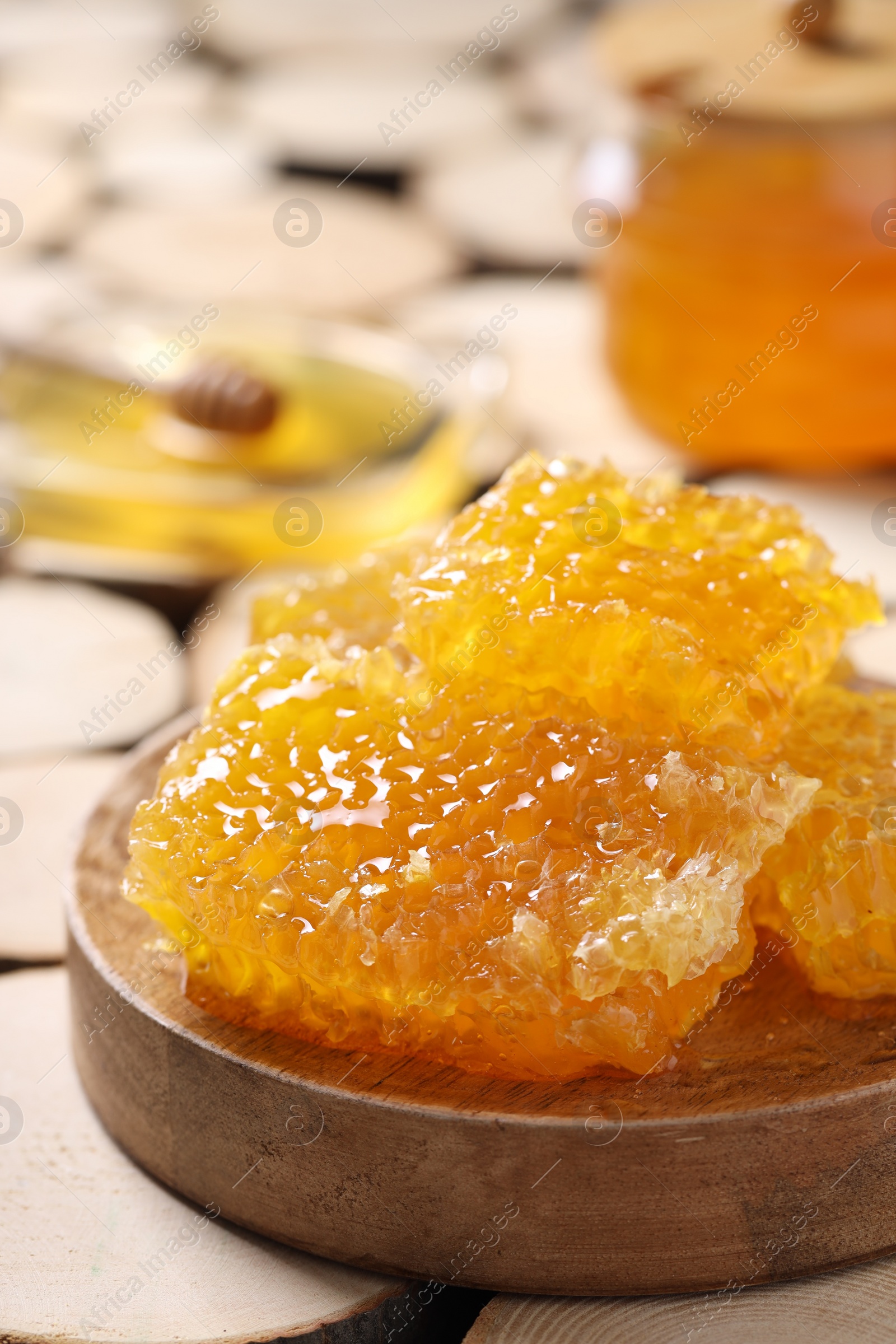 Photo of Natural honeycombs with honey on textured table, closeup. Space for text