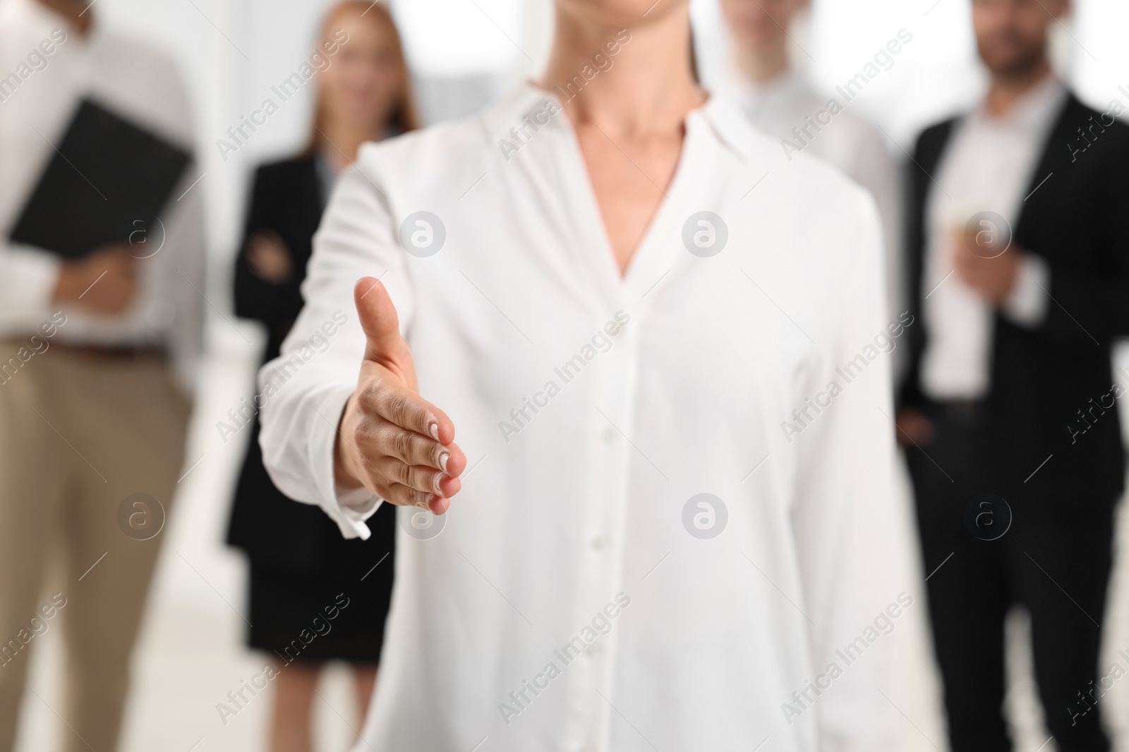 Photo of Woman welcoming and offering handshake indoors, closeup