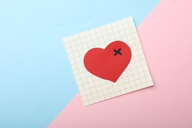 Photo of Paper with drawn heart on color background, top view. Relationship problems concept