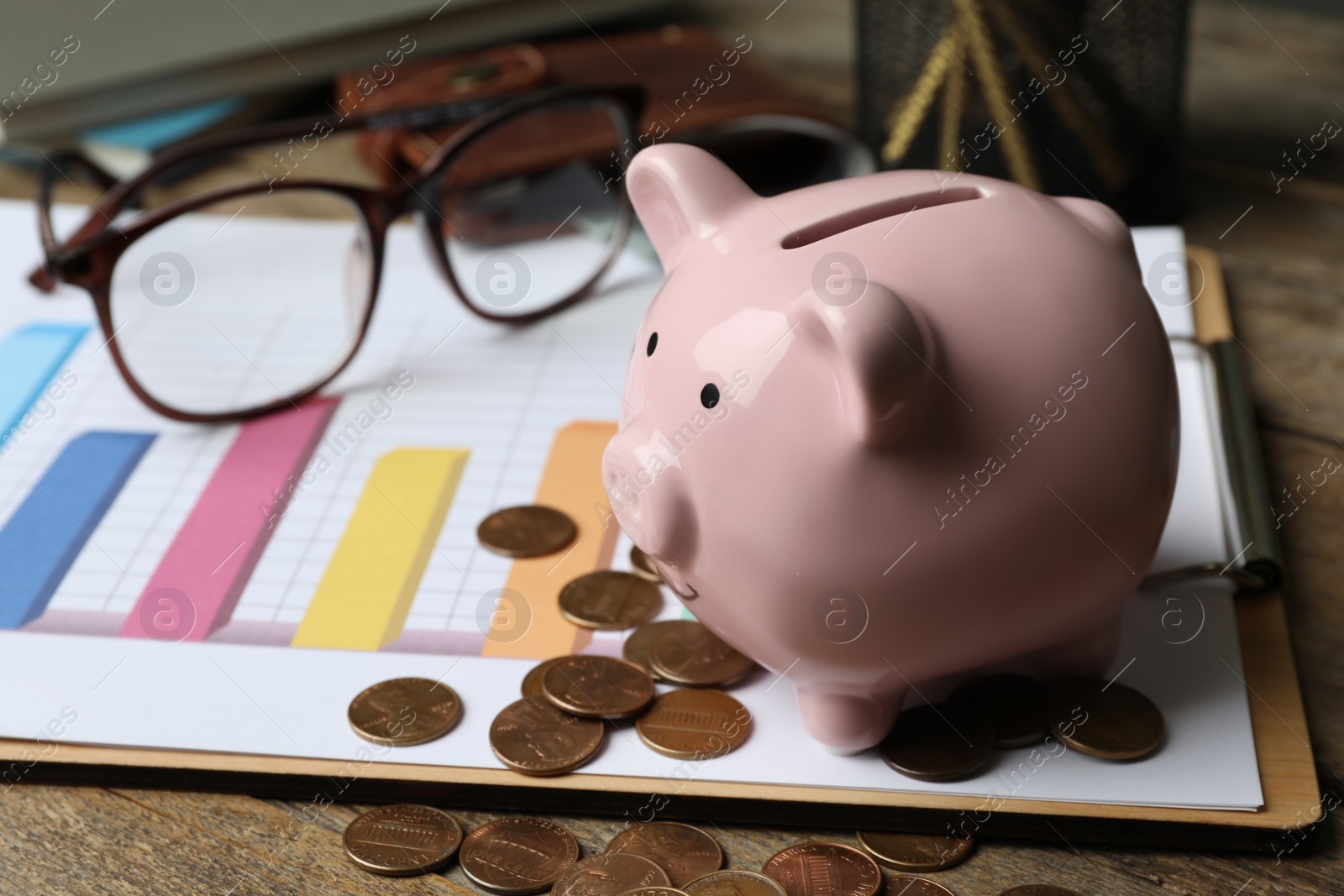 Photo of Piggy bank and money on wooden table, space for text