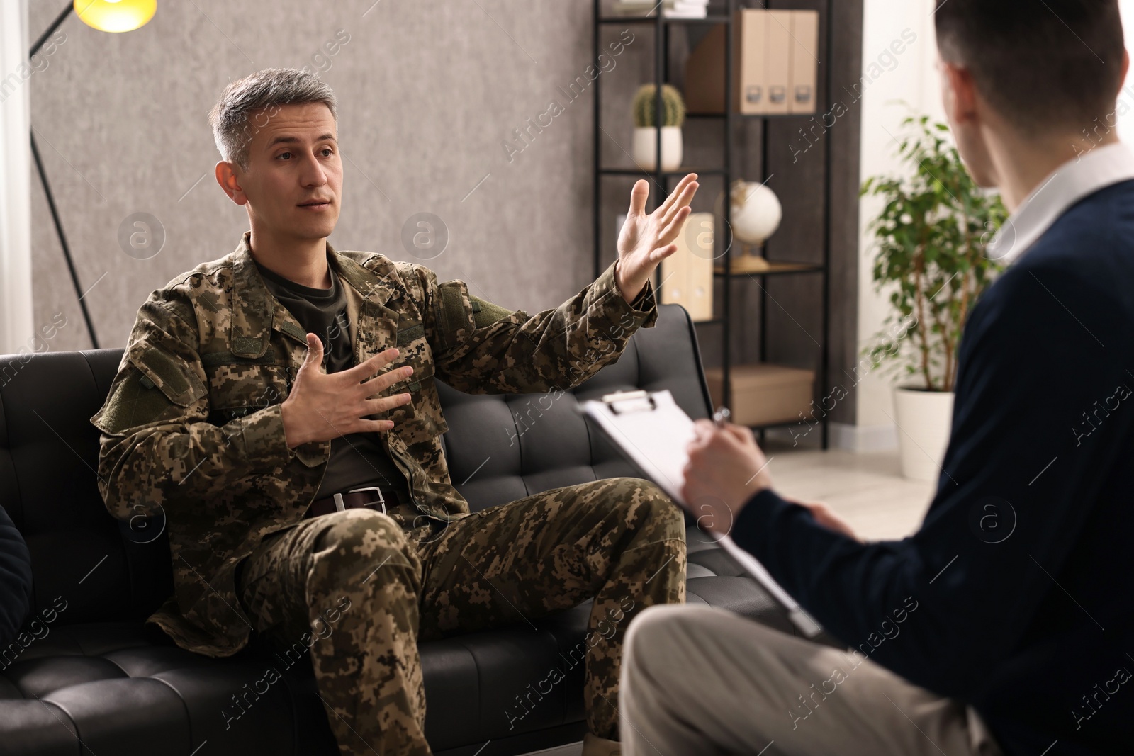 Photo of Professional psychotherapist working with military man in office