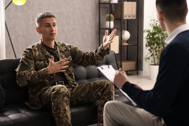 Photo of Professional psychotherapist working with military man in office