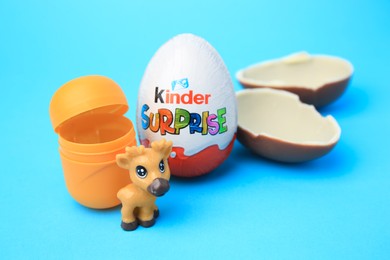Photo of Slynchev Bryag, Bulgaria - May 25, 2023: Kinder Surprise Eggs, plastic capsule and toy deer on light blue background