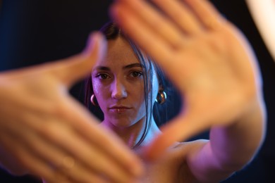 Portrait of beautiful woman on dark background in neon lights