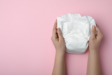 Photo of Woman with diaper on pink background, closeup. Space for text