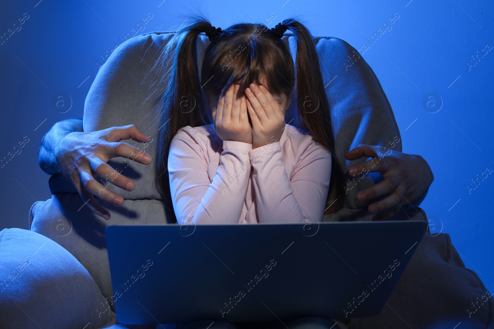 Photo of Stranger reaching frightened little child with laptop on color background. Cyber danger