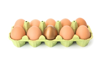 Eggs with golden one in carton on white background