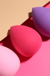 Photo of Many different makeup sponges on color background, closeup
