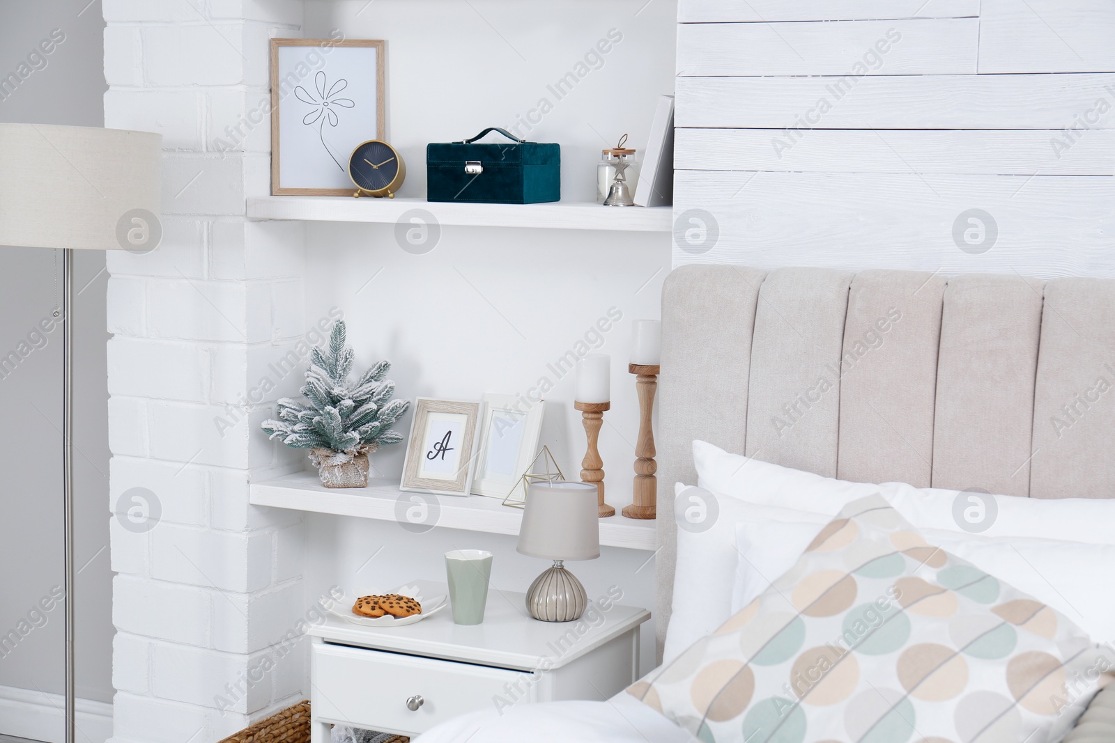 Photo of Wall shelves with beautiful decor elements in stylish bedroom interior