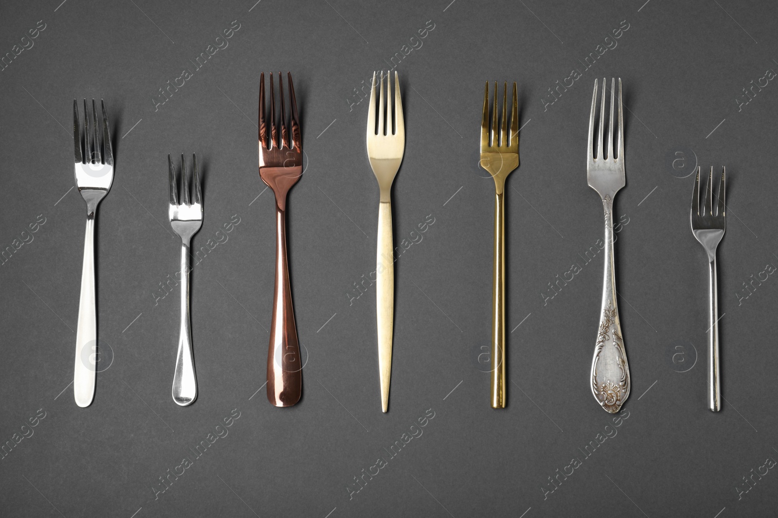 Photo of Set of different forks on black background, flat lay