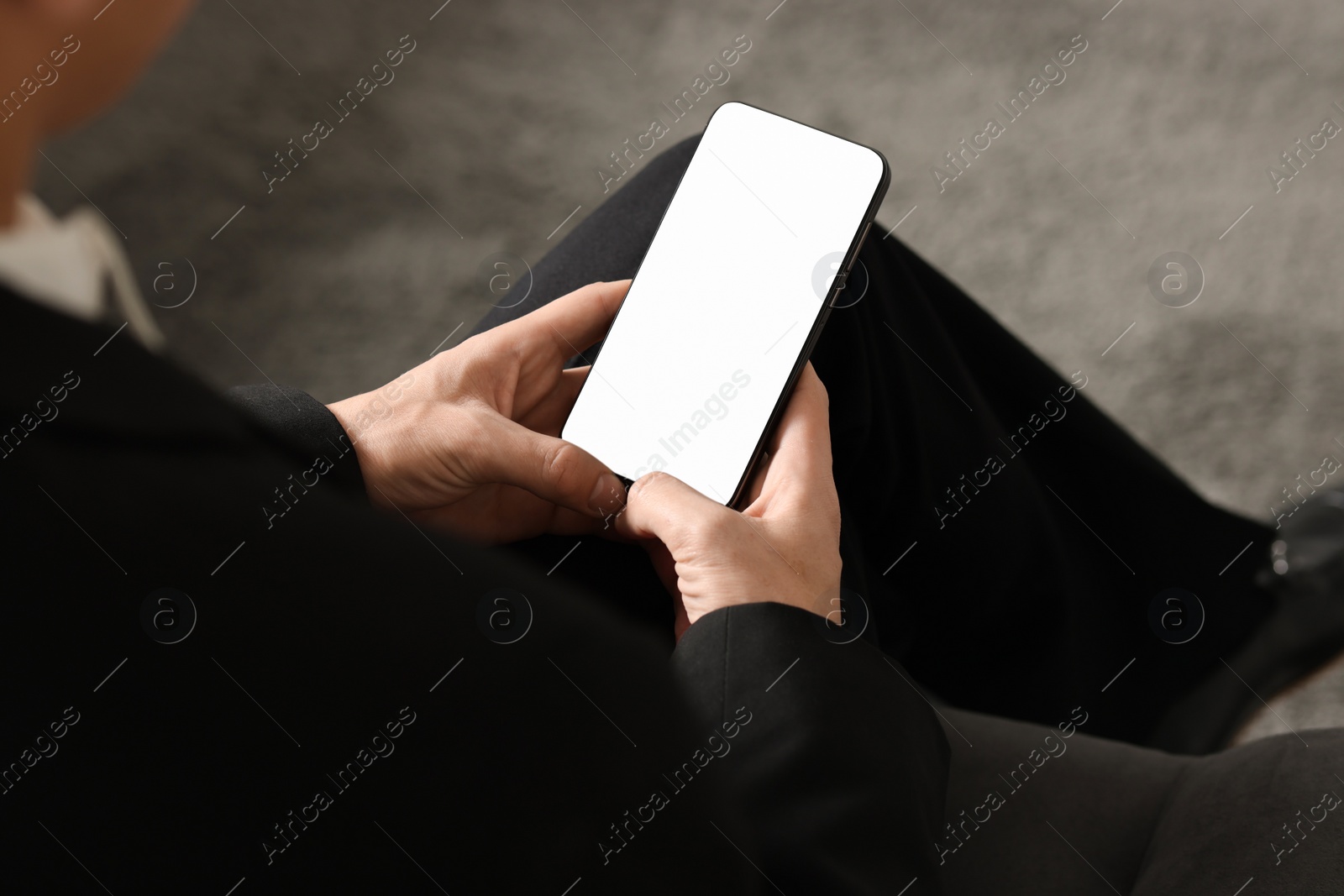 Photo of Man using smartphone with blank screen indoors, closeup. Mockup for design