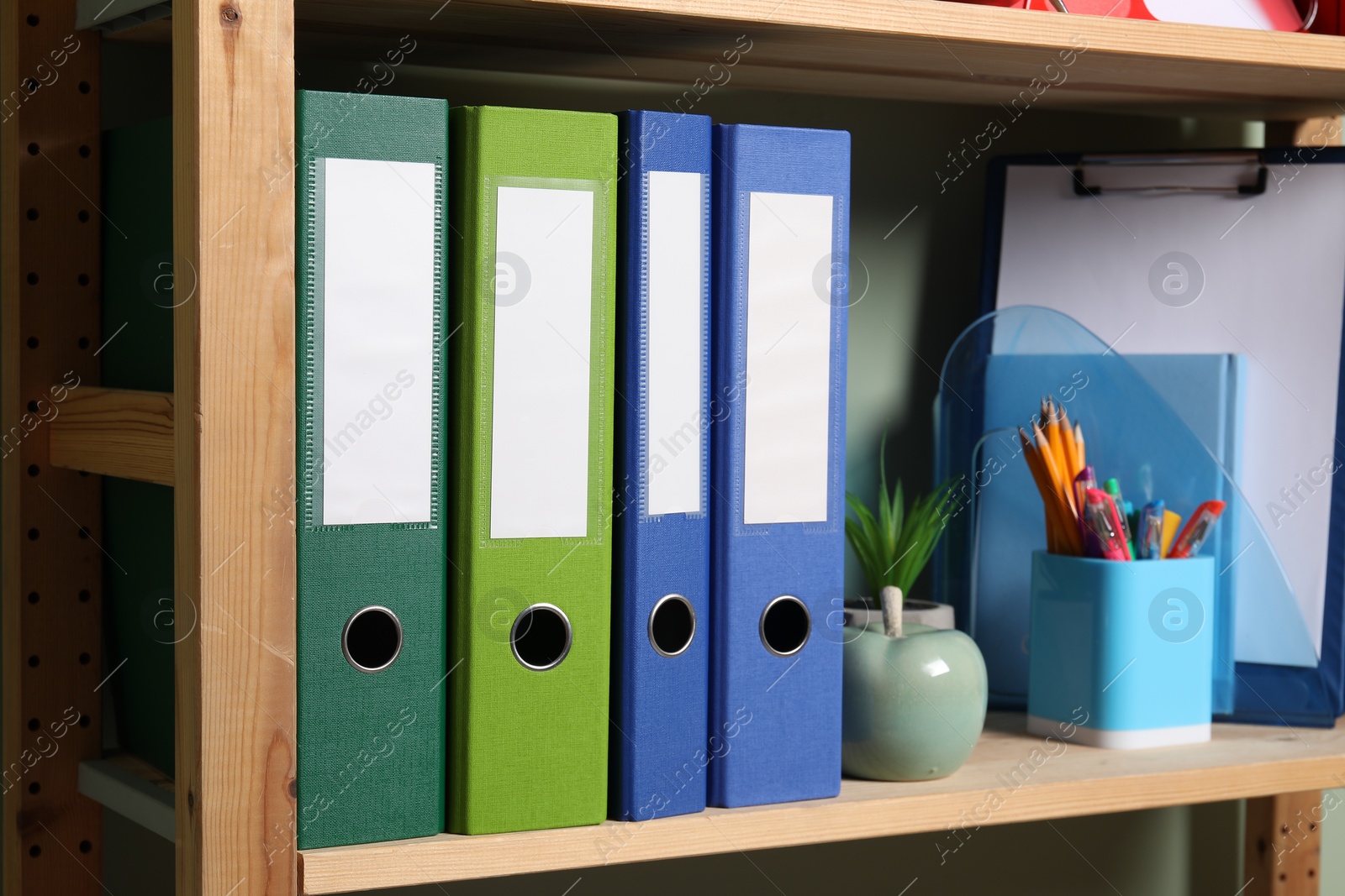 Photo of Colorful binder office folders and other stationery on shelving unit