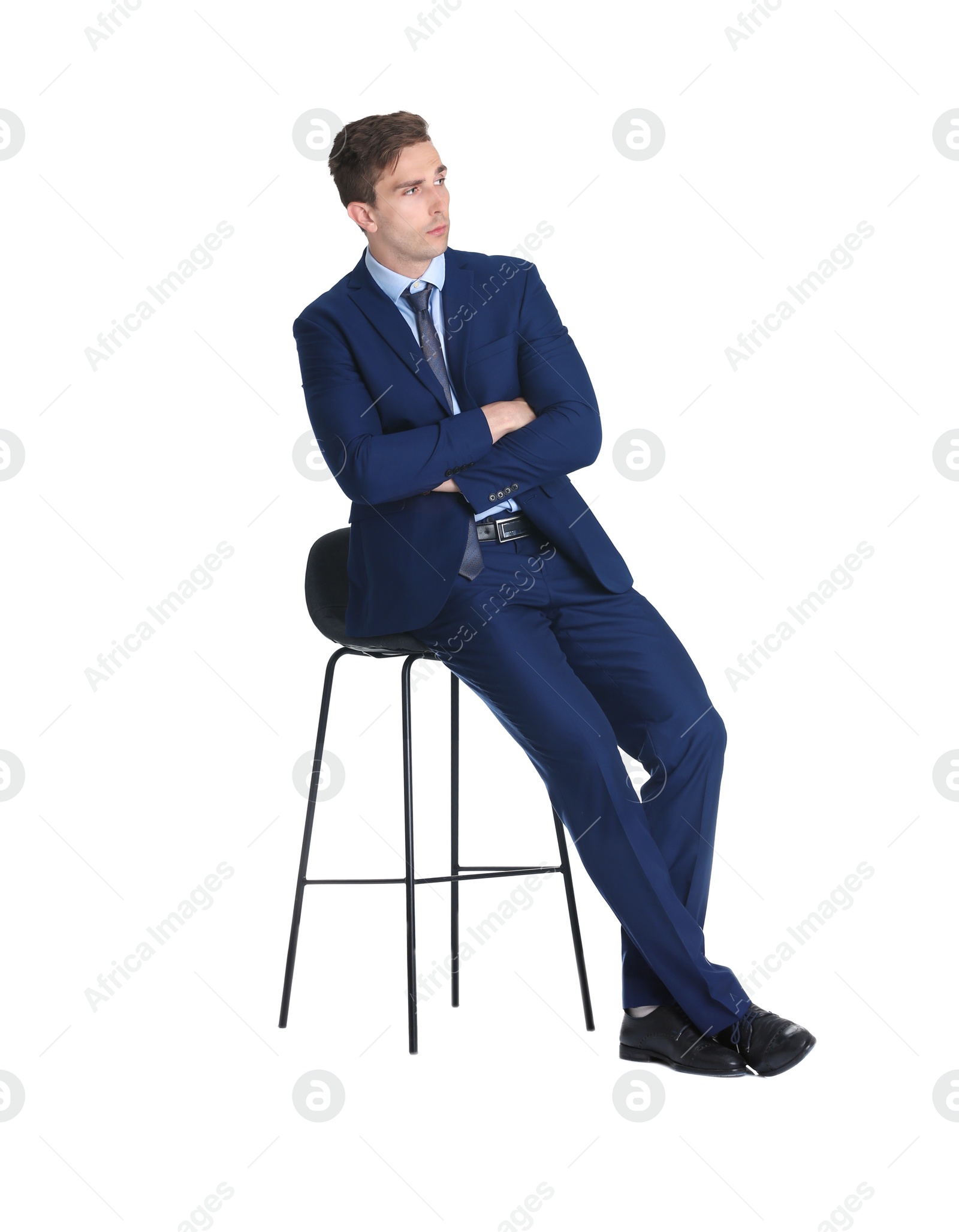 Photo of Handsome young man in suit sitting on chair against white background