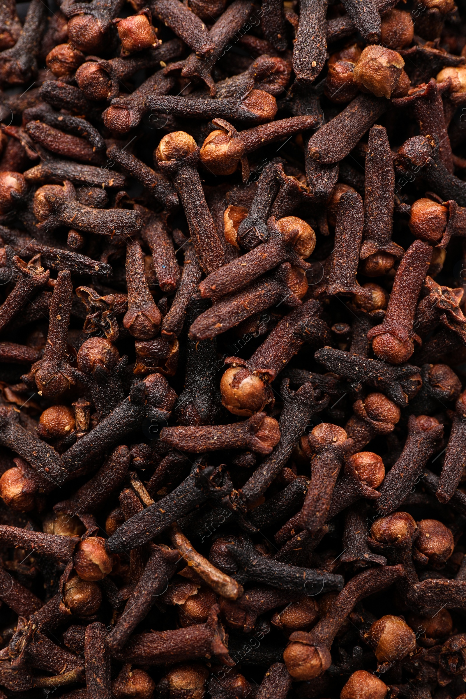 Photo of Pile of aromatic cloves as background, top view