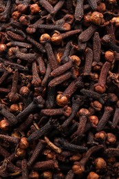 Photo of Pile of aromatic cloves as background, top view