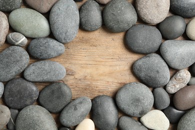 Photo of Frame made with spa stone on wooden table, top view. Space for text