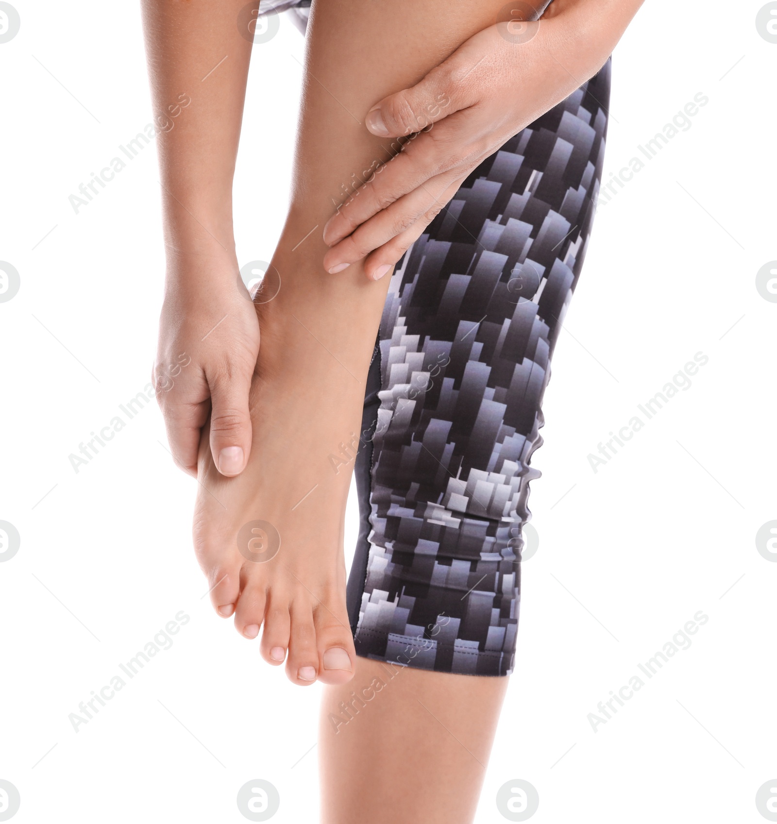 Photo of Young woman suffering from pain in foot on white background, closeup