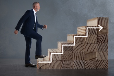 Businessman walking up stairs against grey background. Career ladder concept