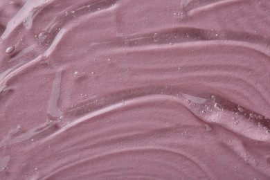 Clear cosmetic serum on pink background, macro view