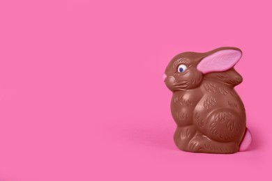 Photo of Chocolate bunny on pink background, space for text. Easter celebration
