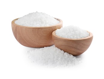 Photo of Wooden bowls and heap of natural sea salt isolated on white