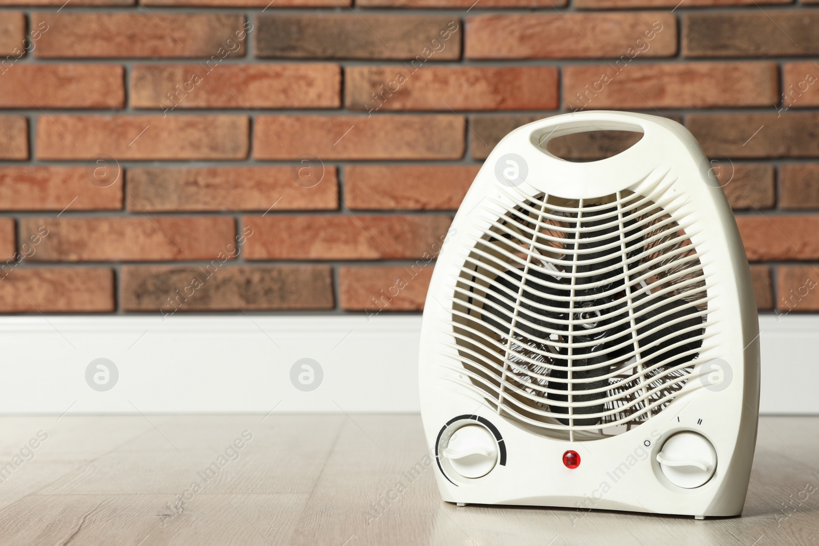 Photo of Modern electric fan heater on floor in room, space for text