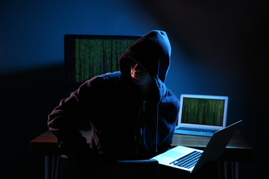 Photo of Hacker with computers in dark room. Cyber crime