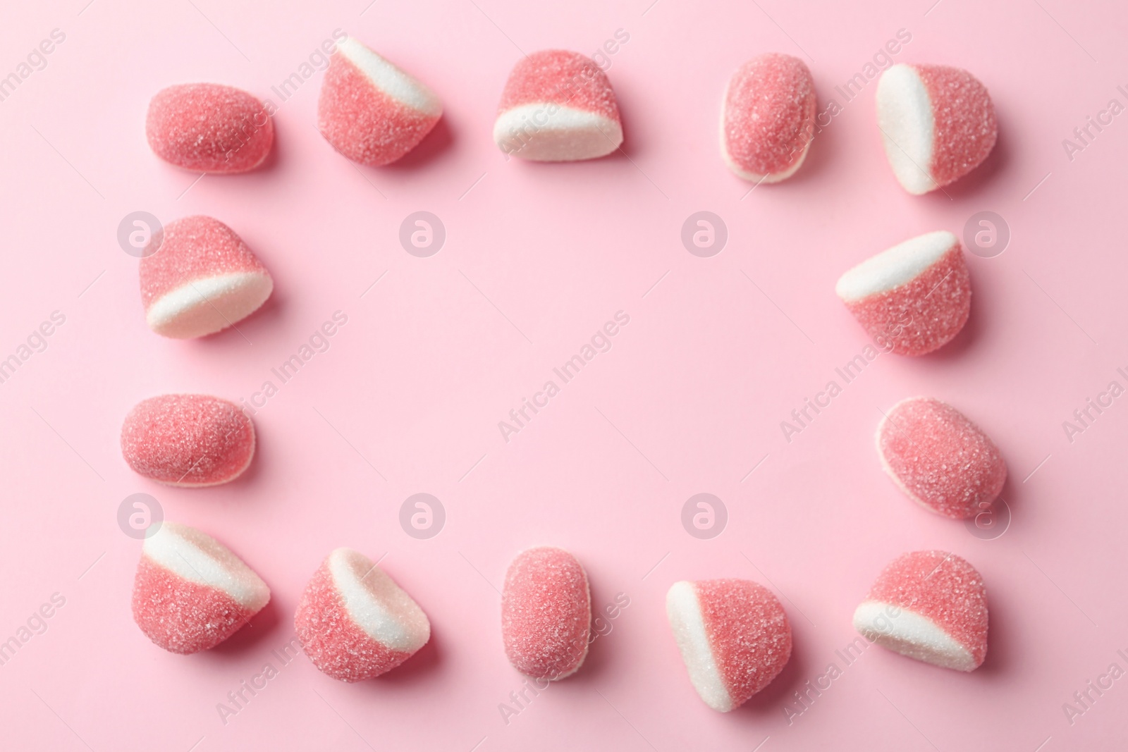 Photo of Frame of sweet jelly candies on pink background, flat lay. Space for text