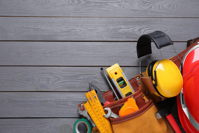 Flat lay composition with different construction tools and space for text on grey wooden background