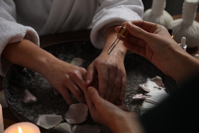 Photo of Woman receiving hand treatment at table in spa, closeup