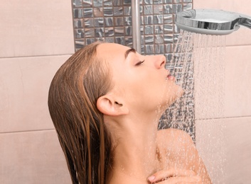 Photo of Beautiful young woman taking shower at home