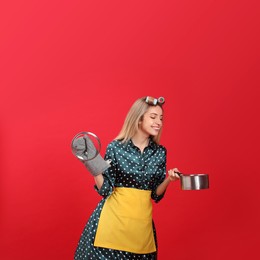 Photo of Young housewife with saucepan on red background