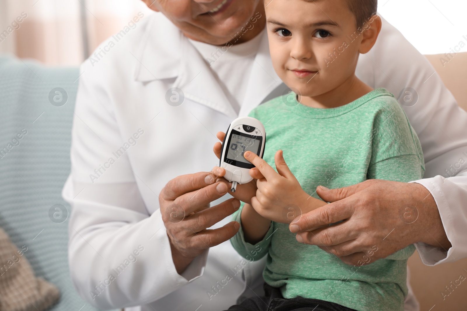 Photo of Doctor measuring patient's blood sugar level with digital glucose meter at home, closeup. Diabetes control