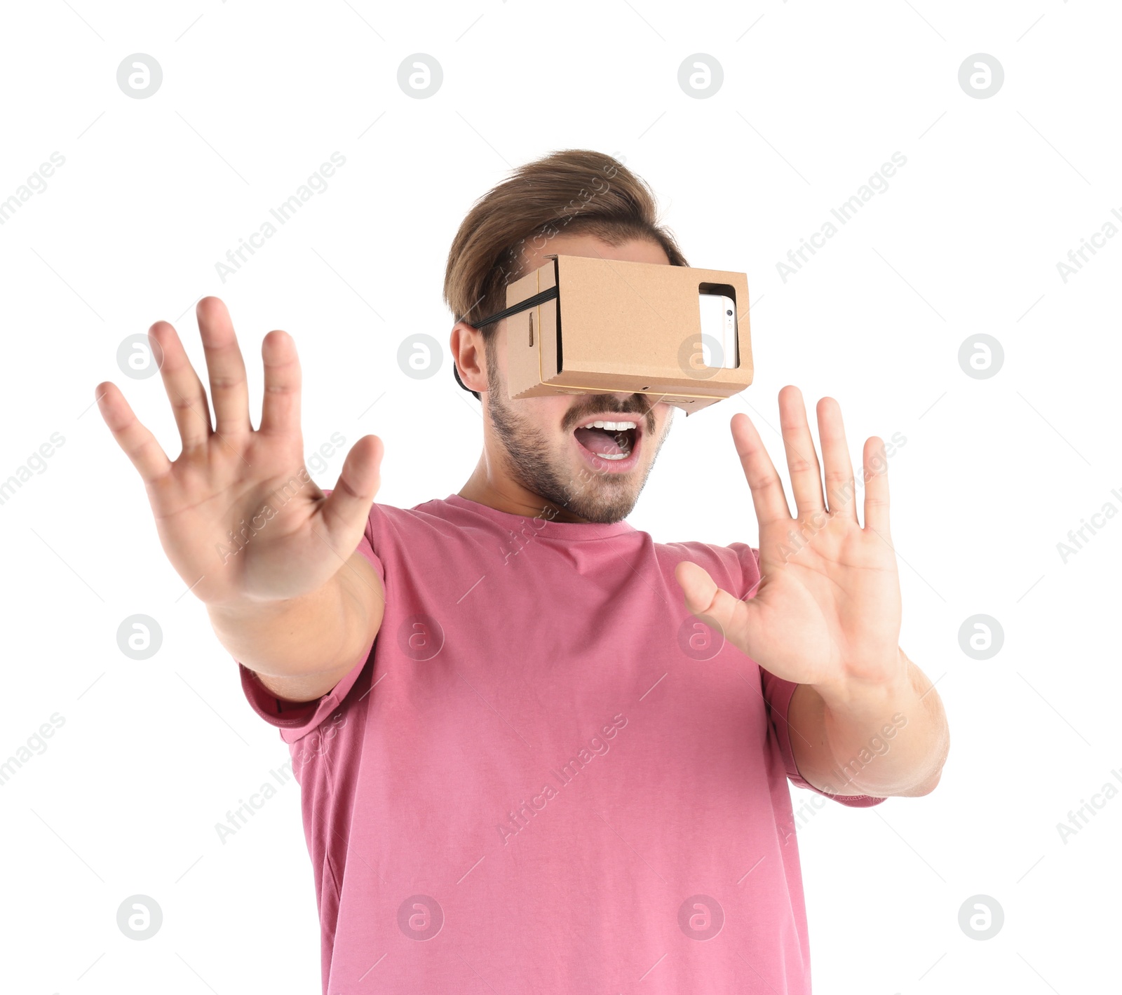 Photo of Young man using cardboard virtual reality headset, isolated on white