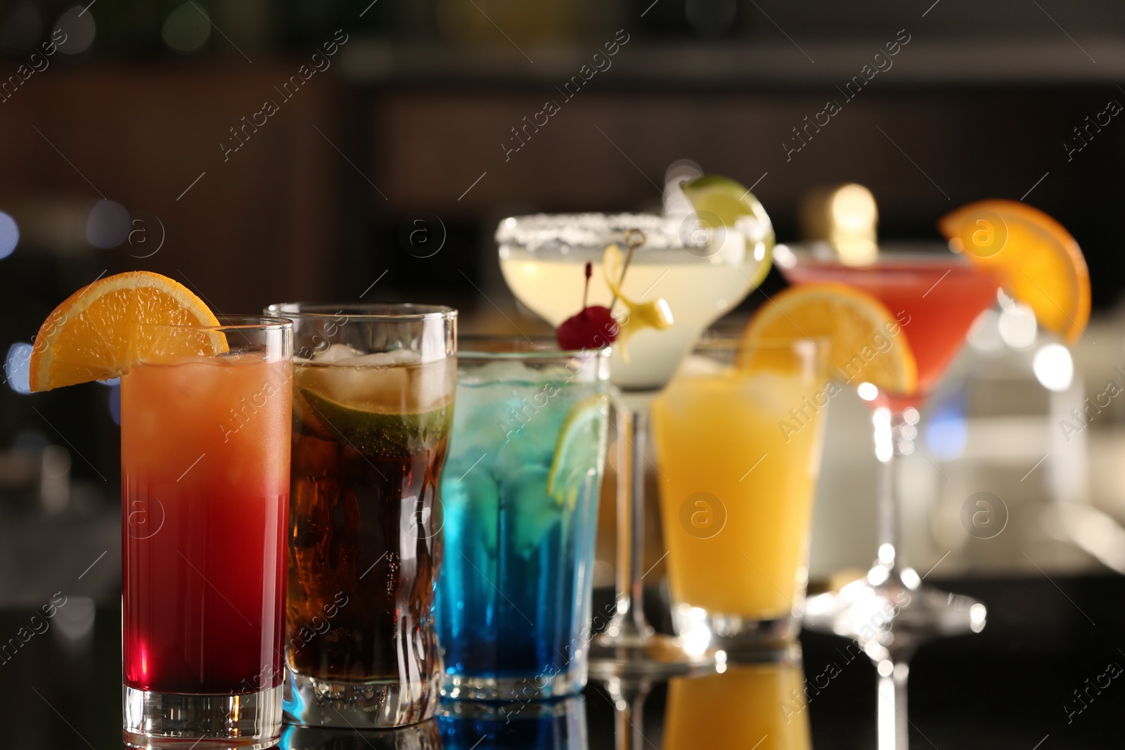 Photo of Different delicious cocktails on counter in bar