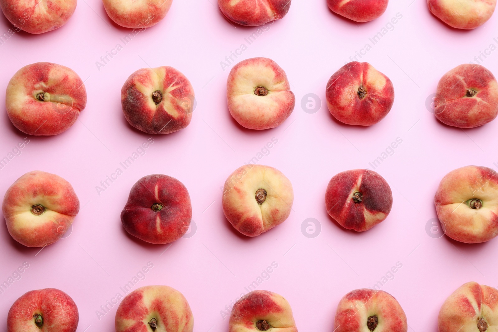 Photo of Fresh donut peaches on light pink background, flat lay