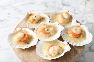 Photo of Fried scallops in shells on white marble table, closeup
