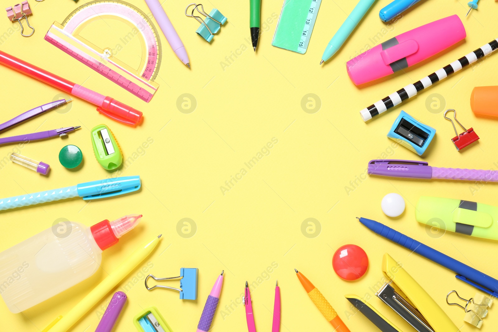 Photo of Frame of different school stationery on yellow background, flat lay. Space for text