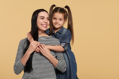 Photo of Happy woman with her daughter on beige background, space for text. Mother's day celebration