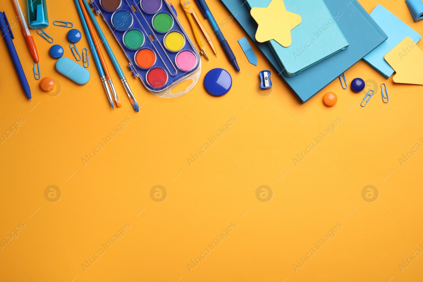 Photo of Different stationery on orange background, flat lay. Space for text