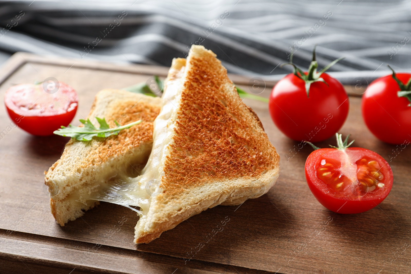 Image of Tasty toast sandwiches with cheese and tomatoes on wooden board