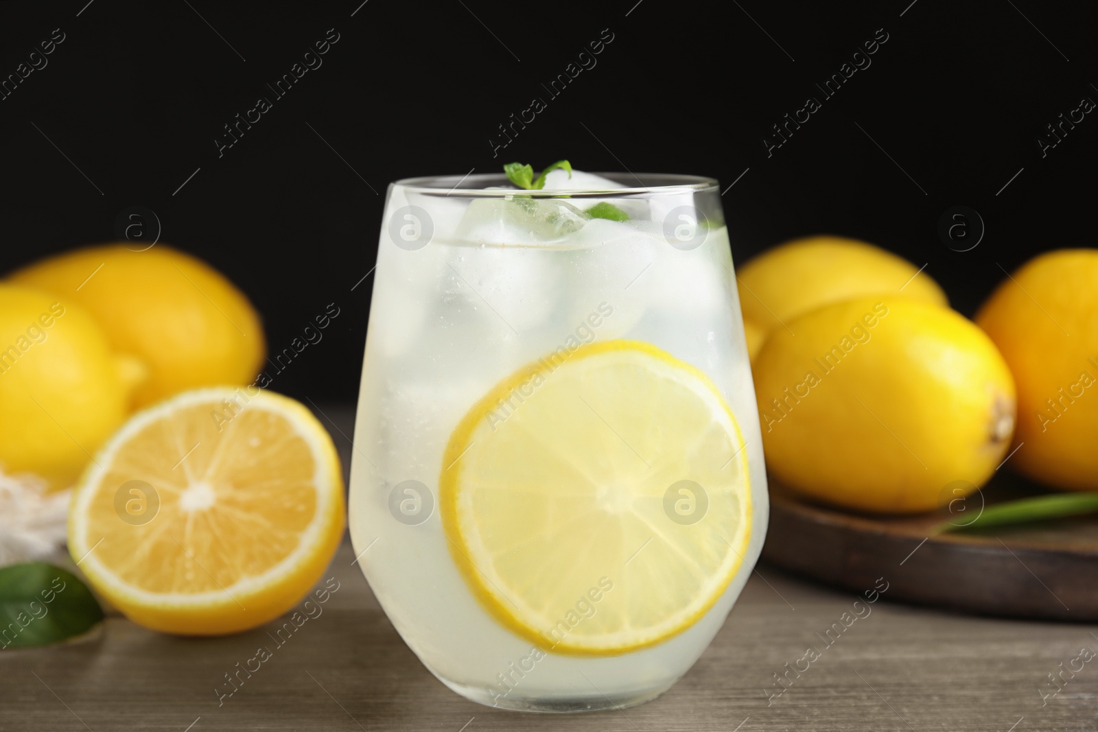 Photo of Cool freshly made lemonade in glass on wooden table, closeup