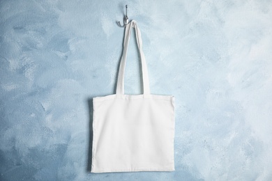 Photo of Tote bag hanging on color wall. Mock up for design
