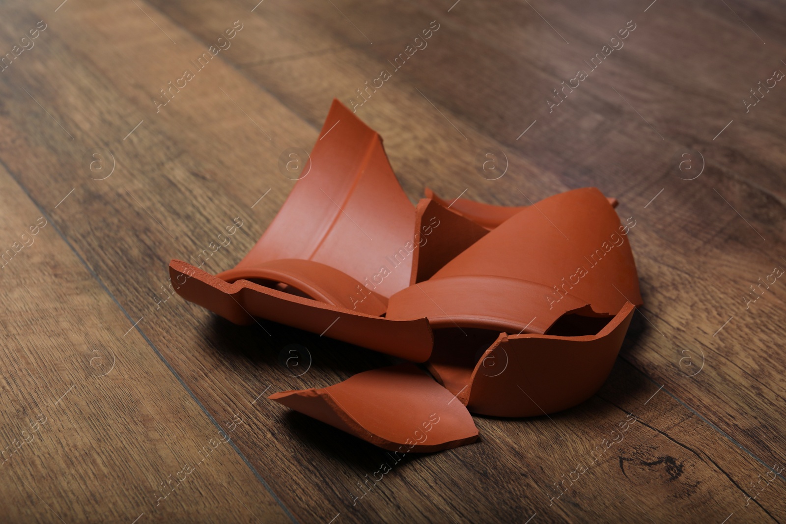 Photo of Broken terracotta flower pot on wooden background