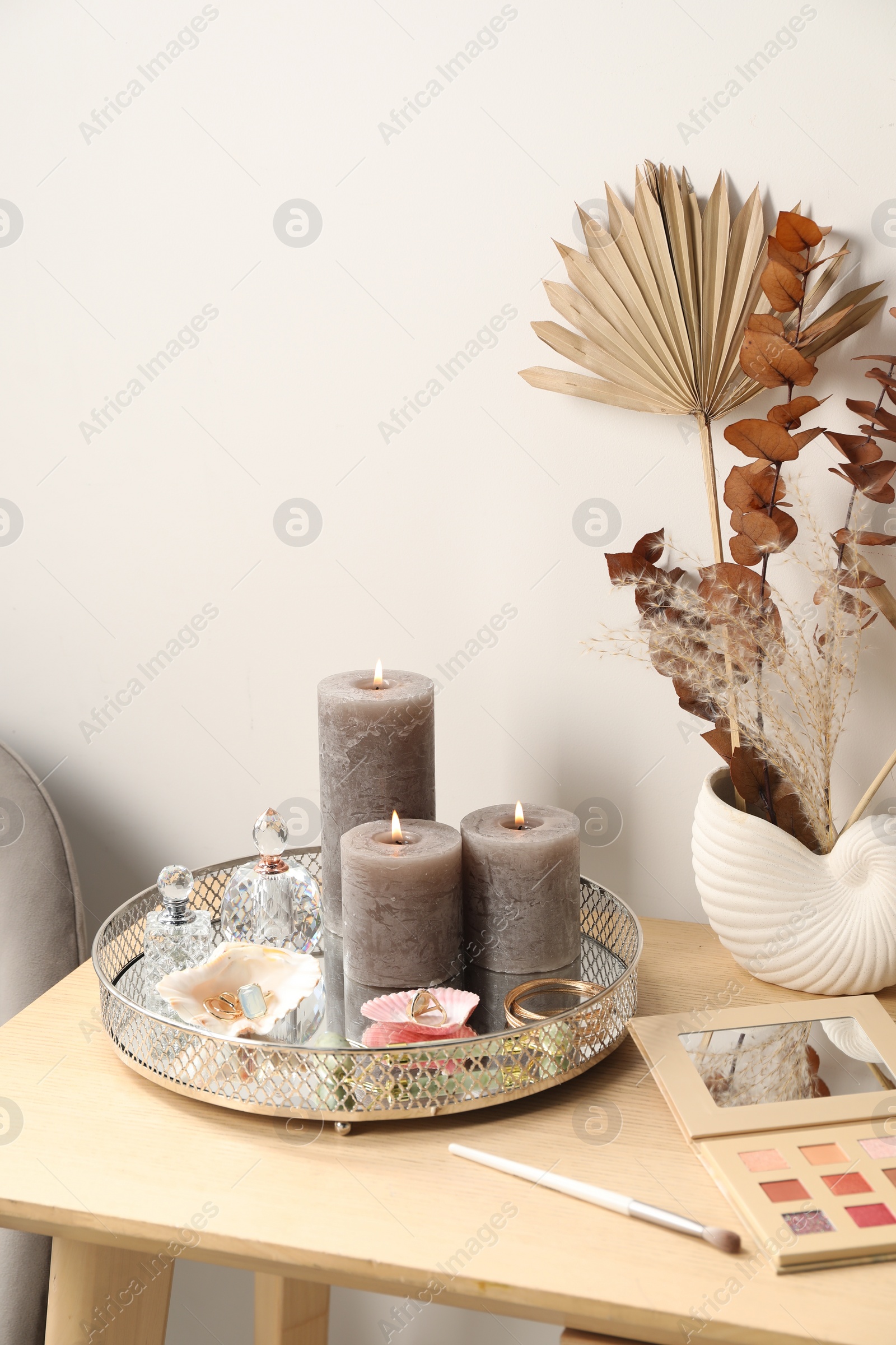Photo of Dressing table with makeup products, accessories and decor in room