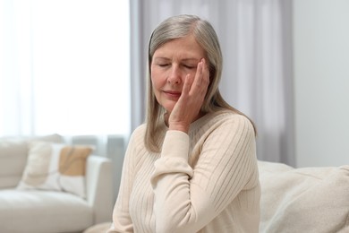 Overwhelmed woman suffering from headache at home