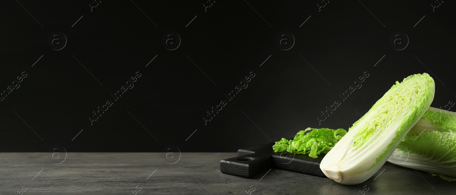 Image of Fresh ripe Chinese cabbages on grey table against black background, space for text. Banner design