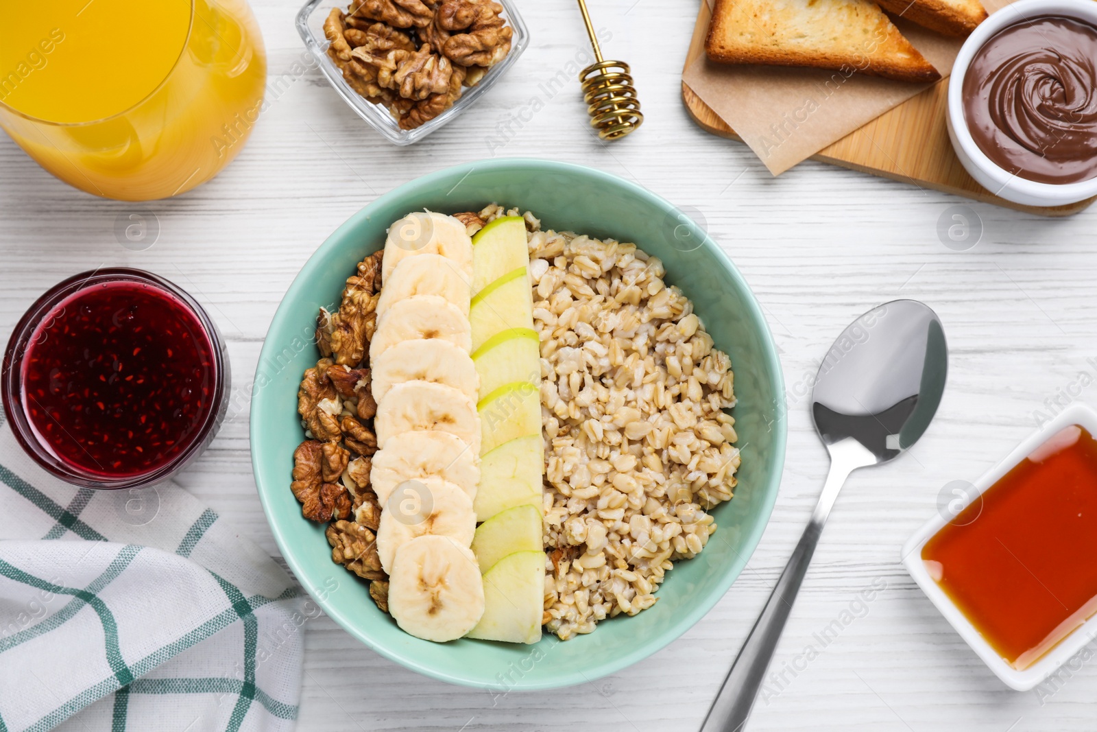 Photo of Tasty breakfast with oatmeal porridge on white wooden table, flat lay