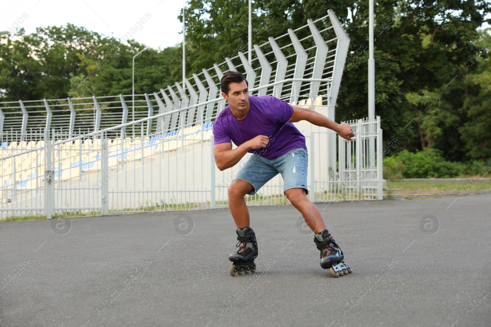 Photo of Handsome young man roller skating outdoors. Recreational activity