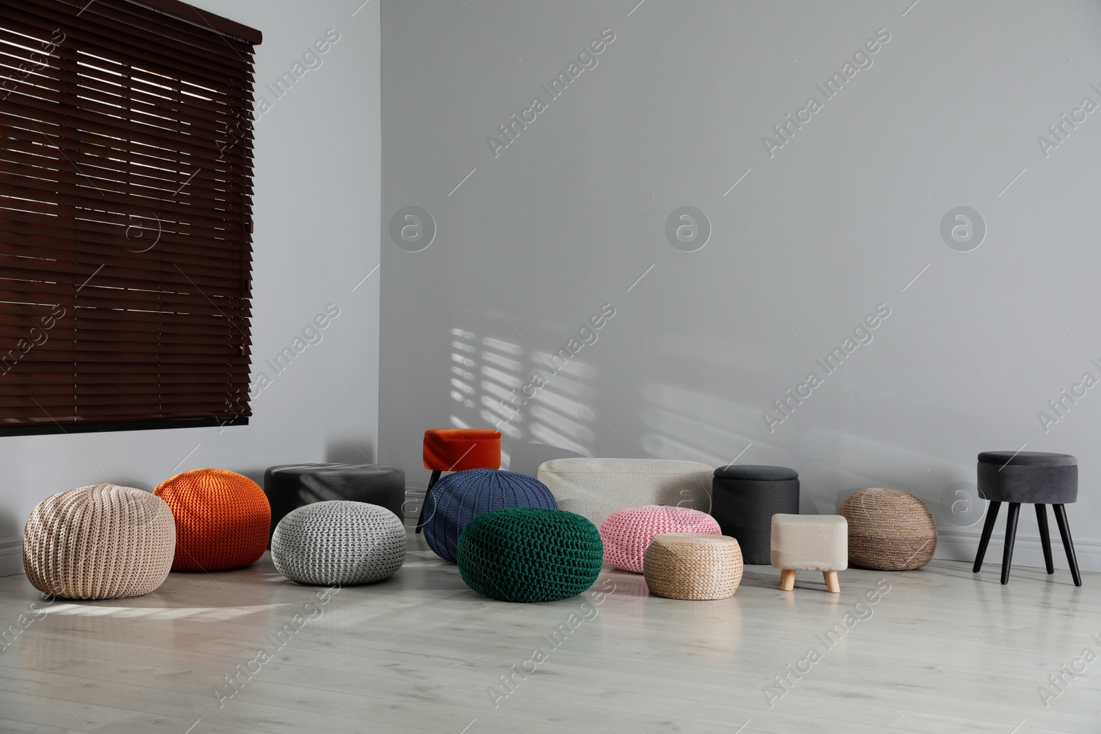 Photo of Many stylish different poufs in room. Home design